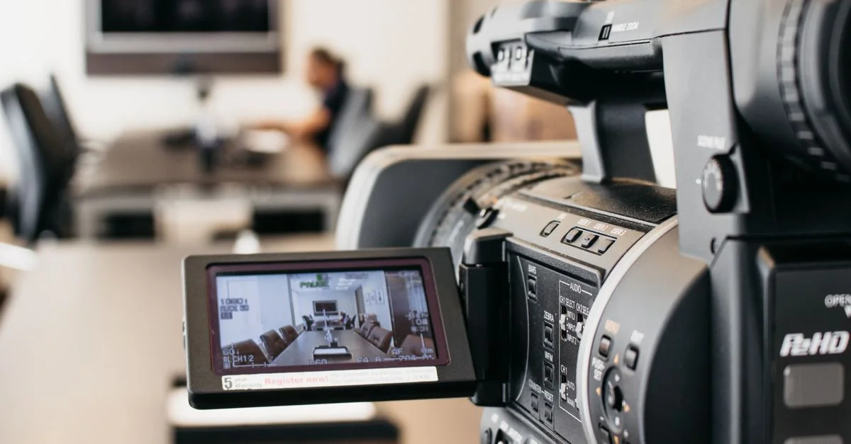 Gros plan d'une caméra vidéo professionnelle enregistrement dans un environnement de bureau moderne.