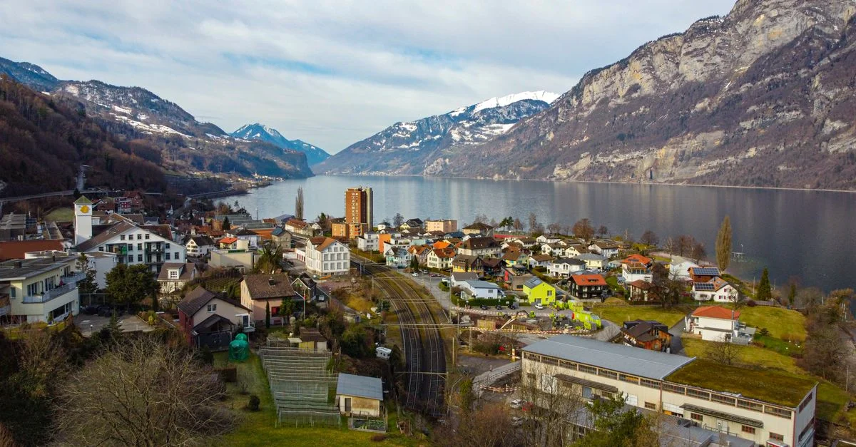 Village alpin idyllique au bord d'un lac paisible avec des montagnes majestueuses en Suisse.