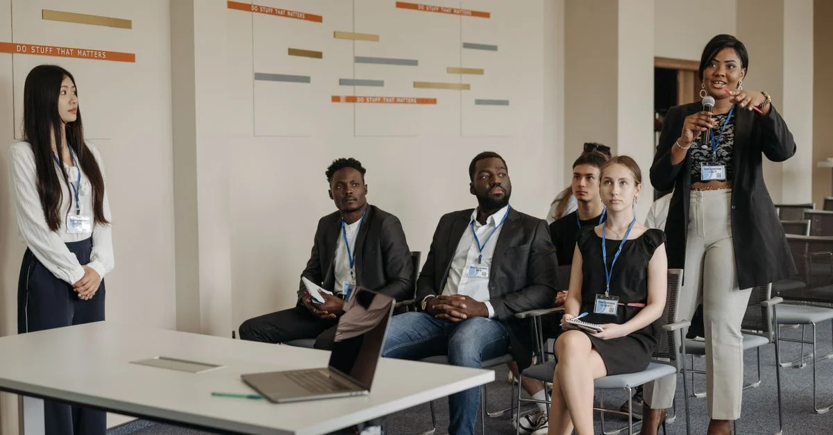 Un groupe diversifié de professionnels assistant à un séminaire d'affaires, participant activement et s'engageant dans des discussions.
